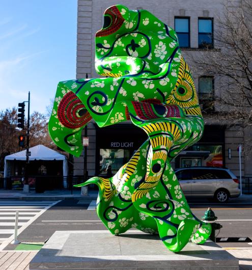Green sculpture seeks to mimic the appearance of a large swatch of African wax printed fabric blowing in the wind. 